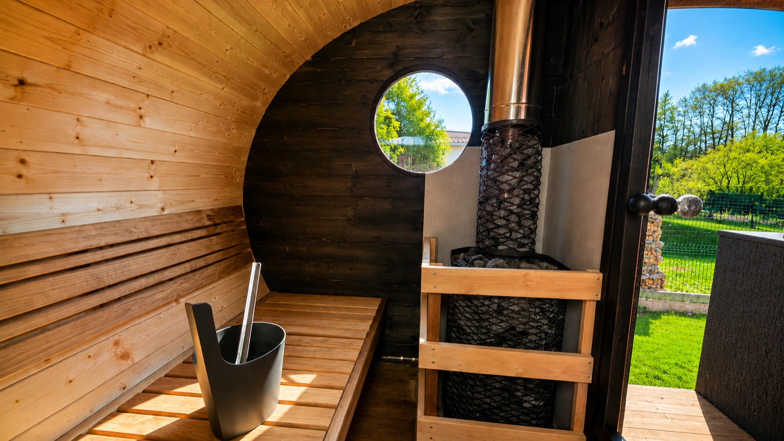 Minispaa sauna sisevaade: puidust pingid, keris ja viht